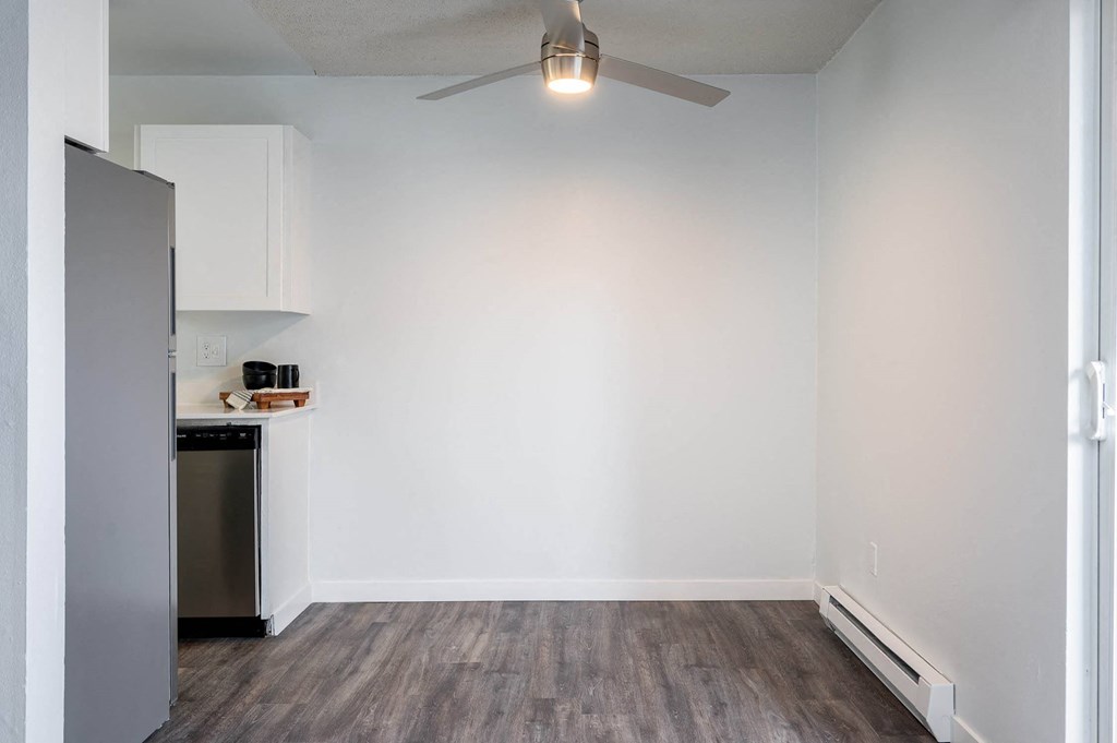 a room with a refrigerator and a ceiling fan